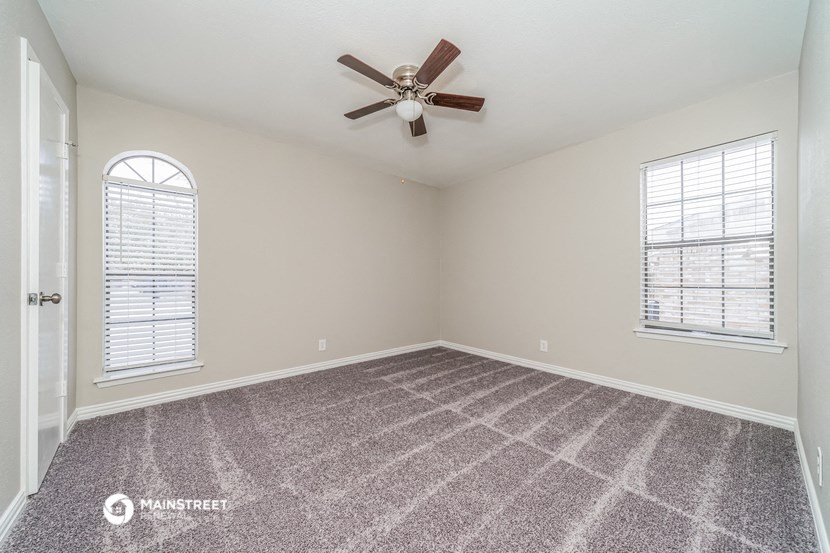 the master bedroom has a ceiling fan and carpeted flooring
