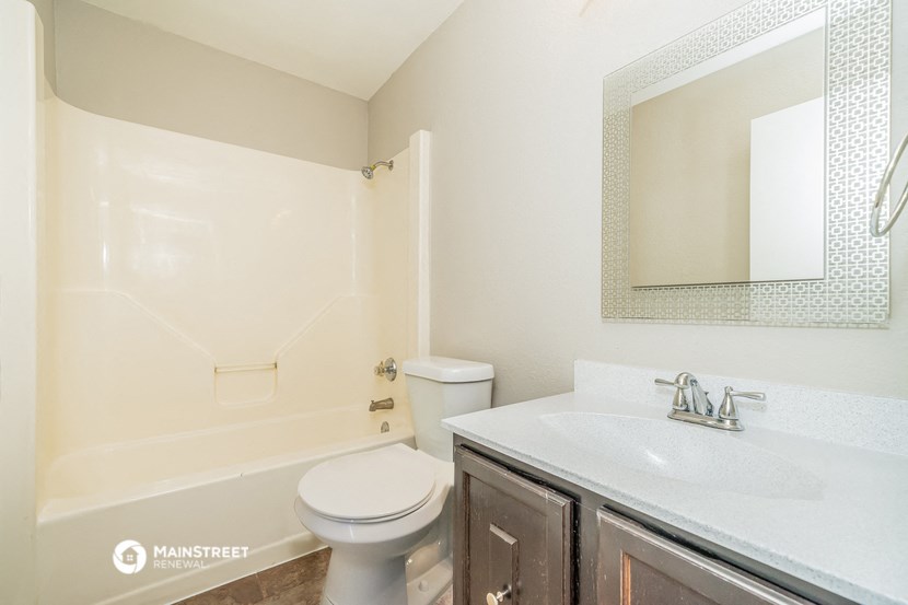 a bathroom with a toilet and a sink and a mirror