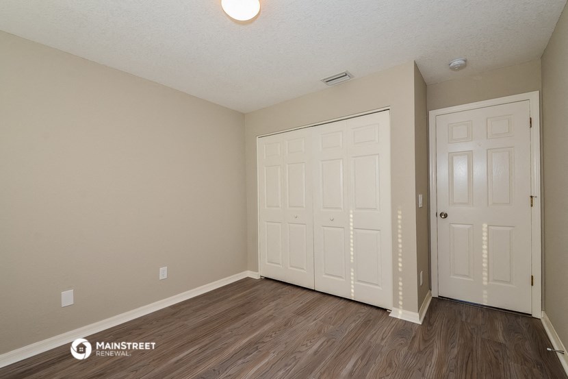 the spacious living room with two closets and wood flooring