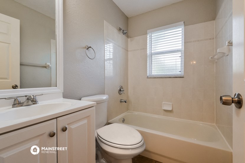 a bathroom with a toilet and a tub and a sink