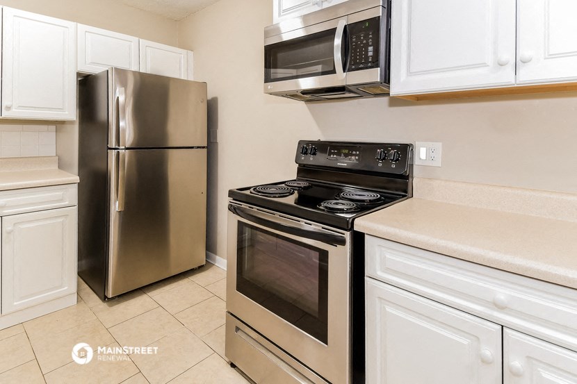 a kitchen with stainless steel appliances and white cabinets