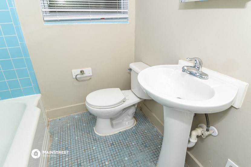 a bathroom with a toilet and a sink and a tub