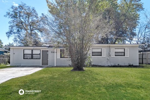 a white house with a tree in front of it