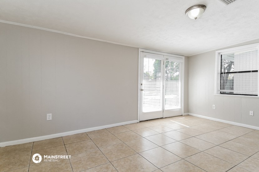 the spacious living room with sliding glass doors to the patio