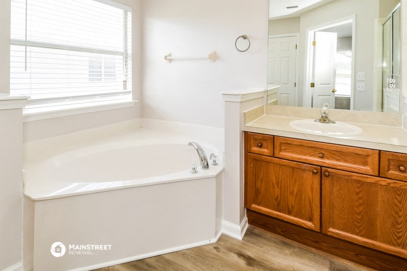 a bathroom with a tub and a sink and a mirror