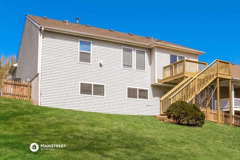 the back of a house with a deck and a yard