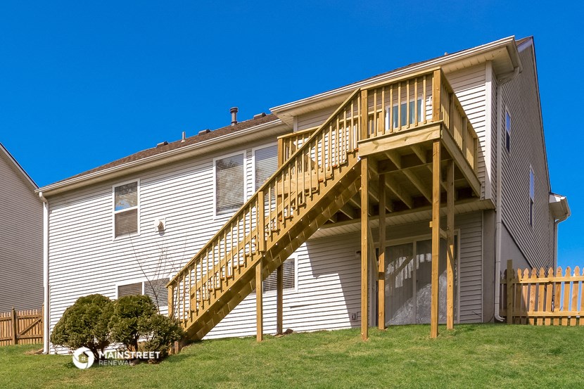 a house with a wooden deck on top of it
