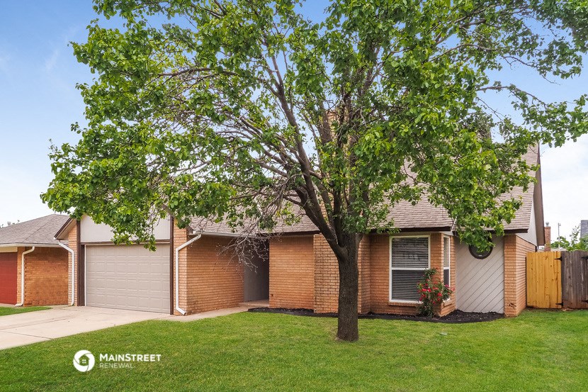 a small brick house with a tree in the yard