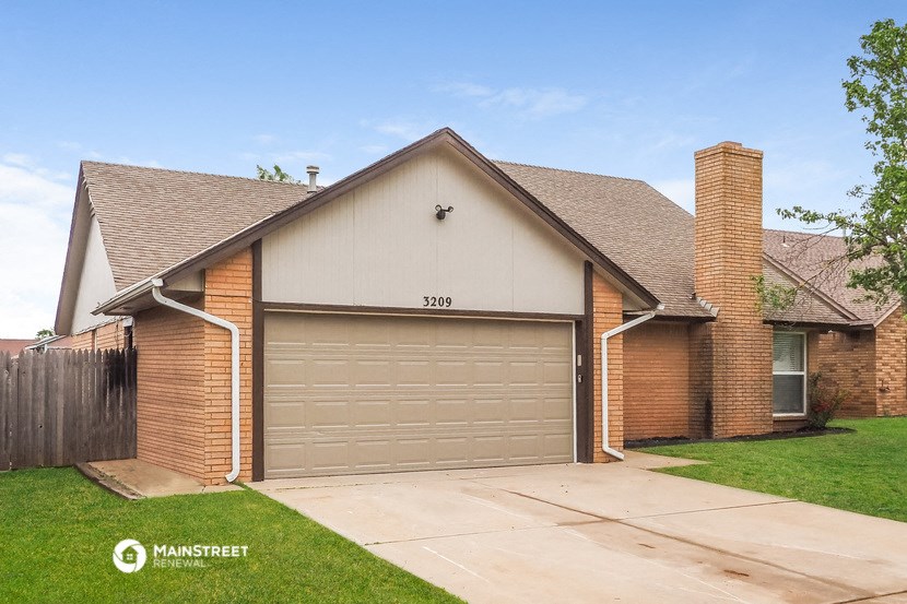 a garage door in front of a brick house