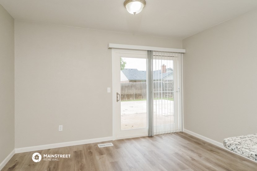 the spacious living room with sliding glass doors to the backyard