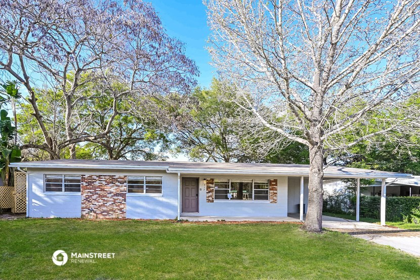 a small white house with a tree in front of it