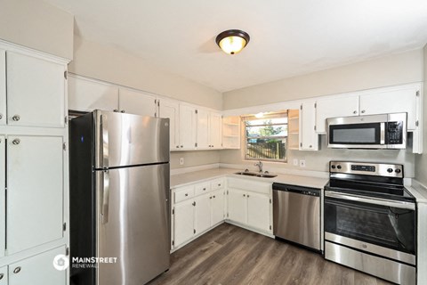a kitchen with stainless steel appliances and white cabinets