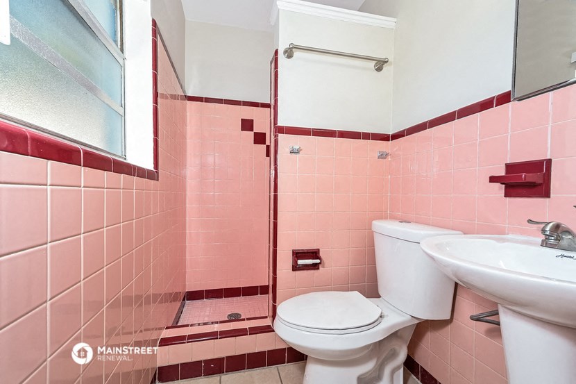 a bathroom with pink tiles and a toilet and a sink