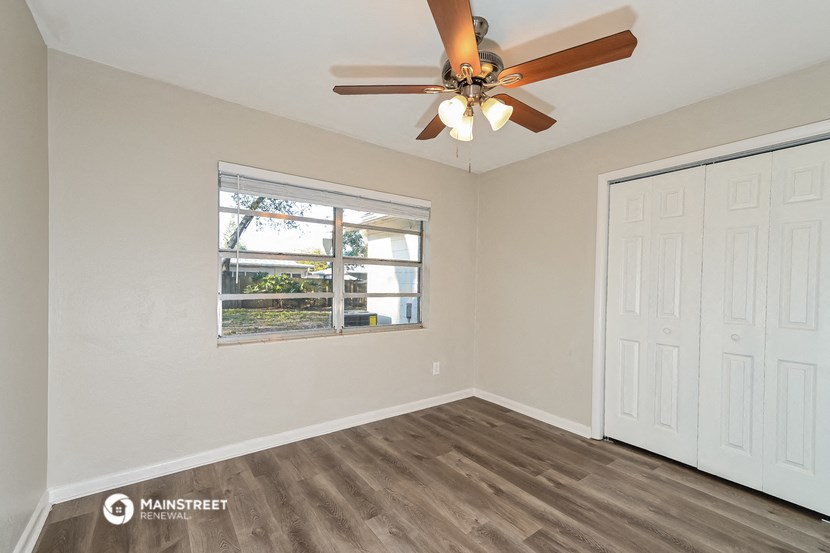 the living room of a home with a ceiling fan and a window