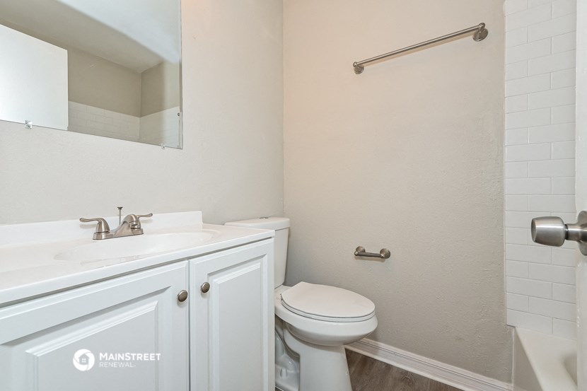 a bathroom with a sink toilet and a mirror