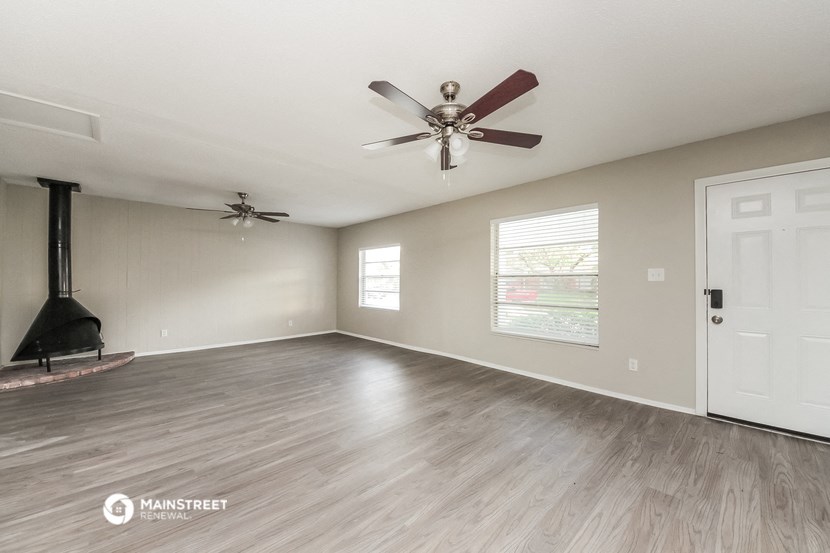 the living room has a fireplace and a ceiling fan