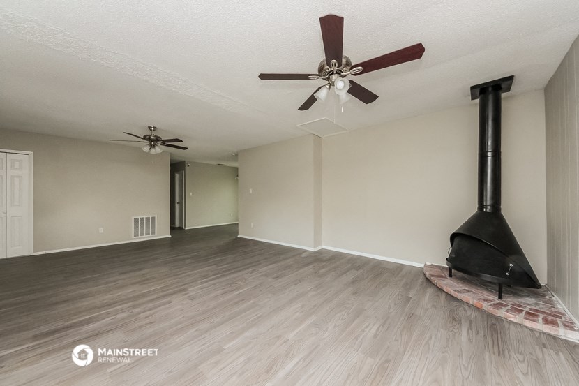 a living room with a fireplace and a ceiling fan