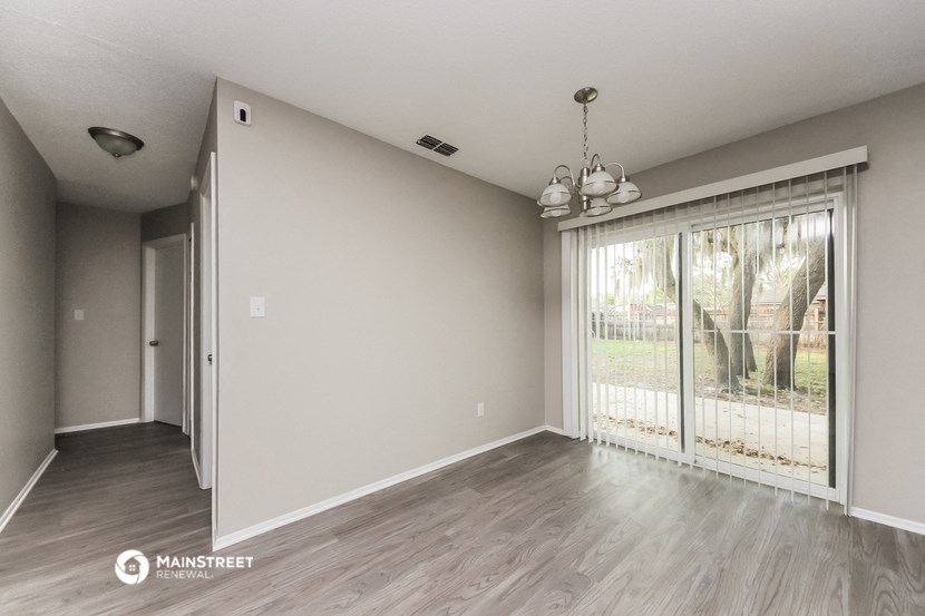 an empty living room with a sliding glass door to a patio
