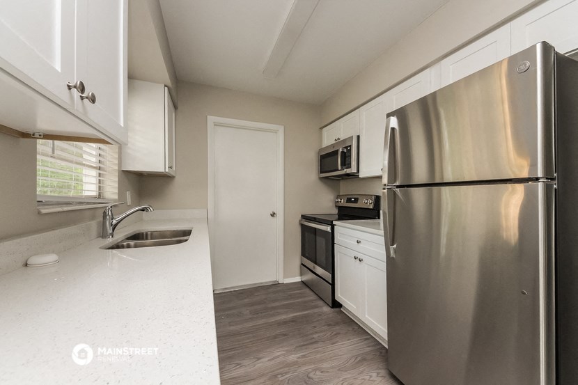 a kitchen with stainless steel appliances and white cabinets