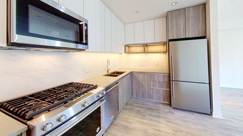 a modern kitchen with stainless steel appliances and white cabinets