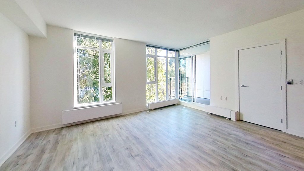 an empty living room with white walls and a large window