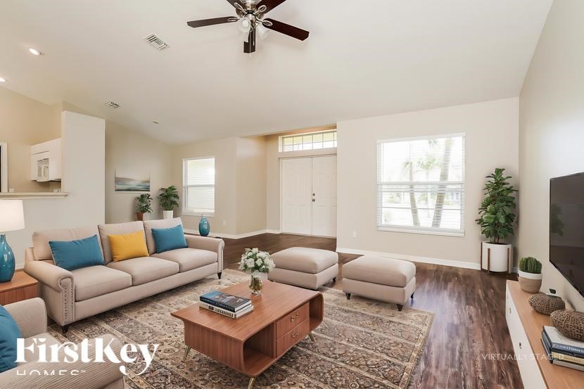 A living room with a couch, a coffee table, and a ceiling fan.