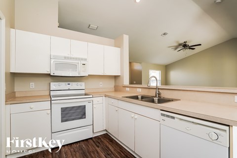 A kitchen with white cabinets and appliances.