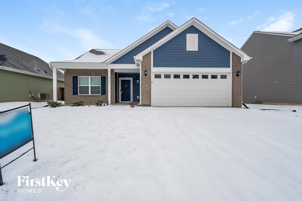 a garage door in the snow in front of a house