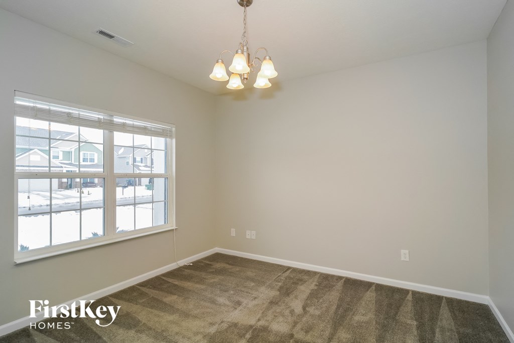 the living room of a home with a carpeted floor and a large window