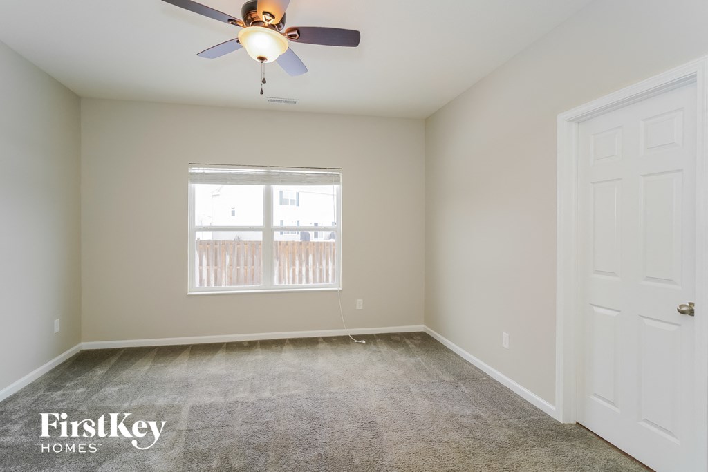 a bedroom with a ceiling fan and a window