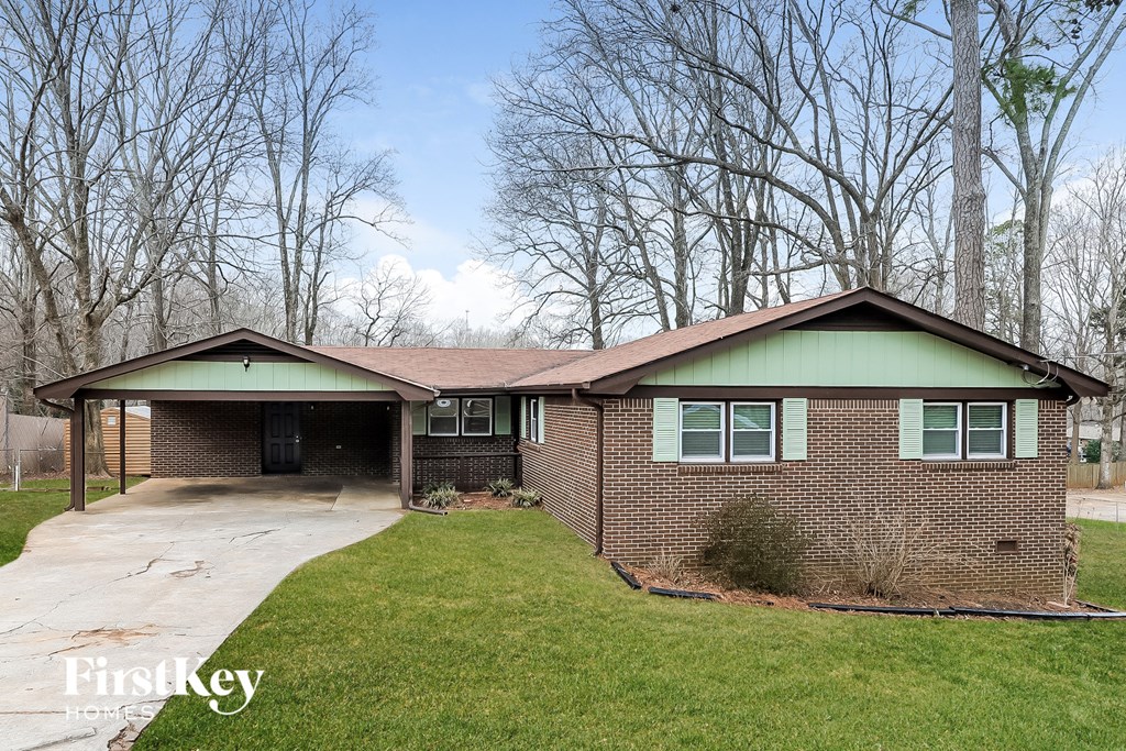 front view of a brick house with green roof and a driveway