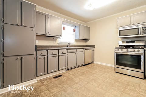 a kitchen with stainless steel appliances and gray cabinets