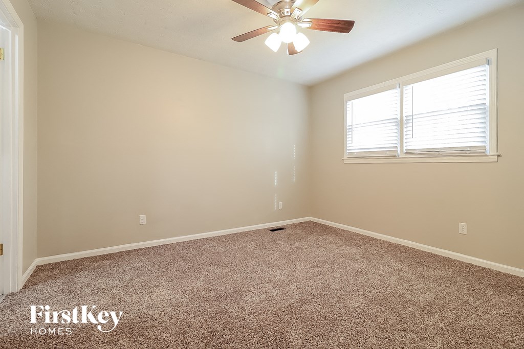 the master bedroom has carpeted floors and a ceiling fan