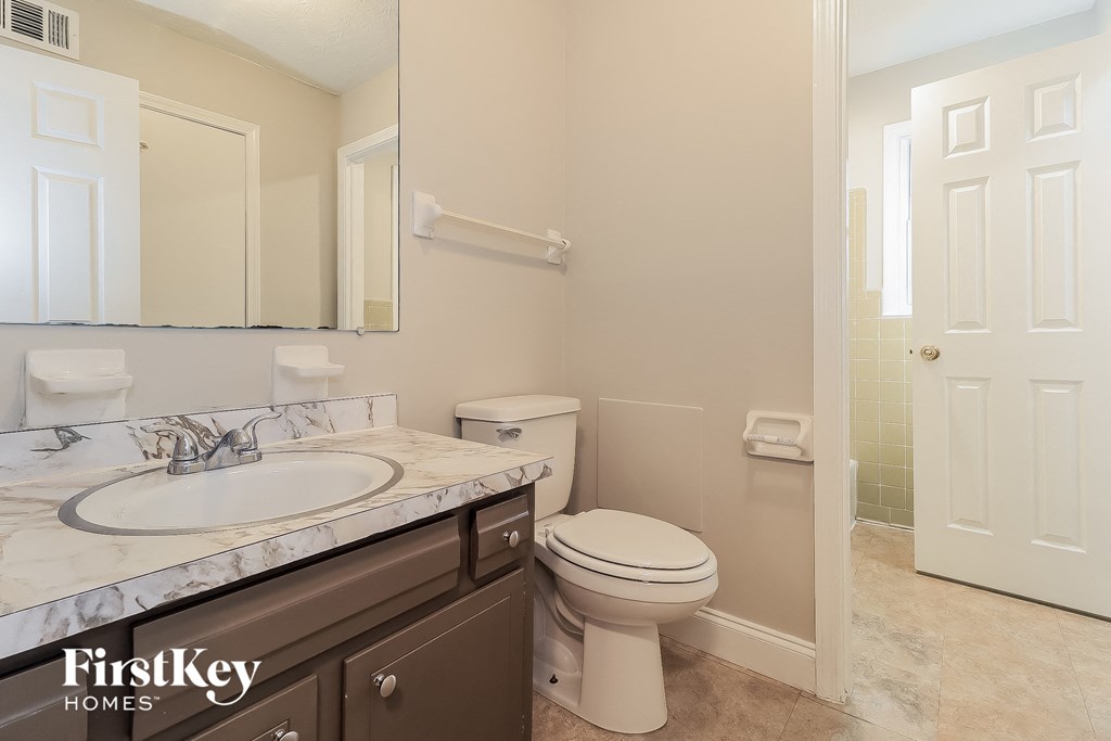 a bathroom with a toilet and a sink and a mirror