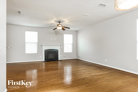a living room with a fireplace and a ceiling fan