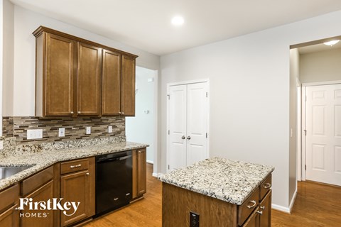 a kitchen with granite counter tops and wooden cabinets