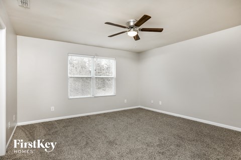 a living room with carpet and a ceiling fan