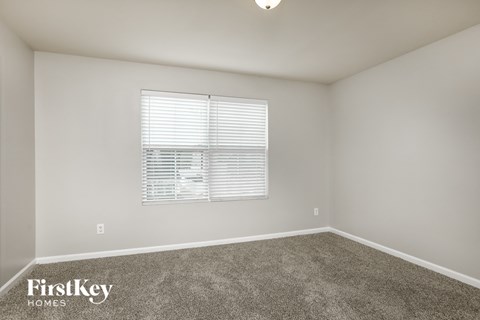 a spacious room with carpet and a window