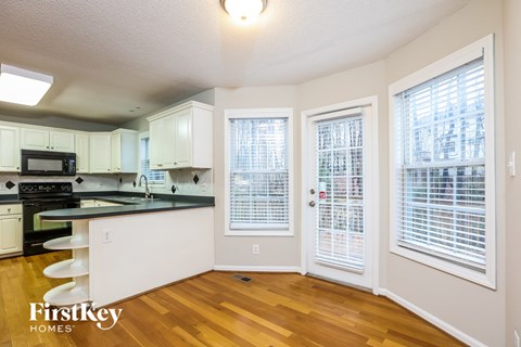 A kitchen with a black counter top and white cabinets.