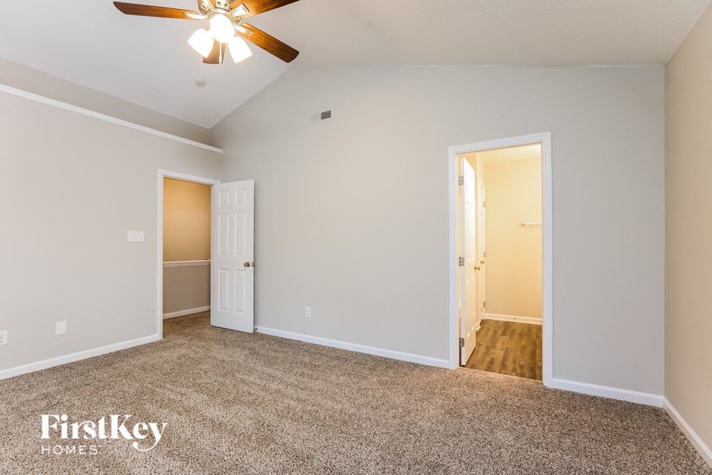 A room with a ceiling fan and two doors.