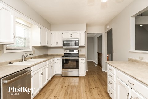a kitchen with white cabinets and stainless steel appliances