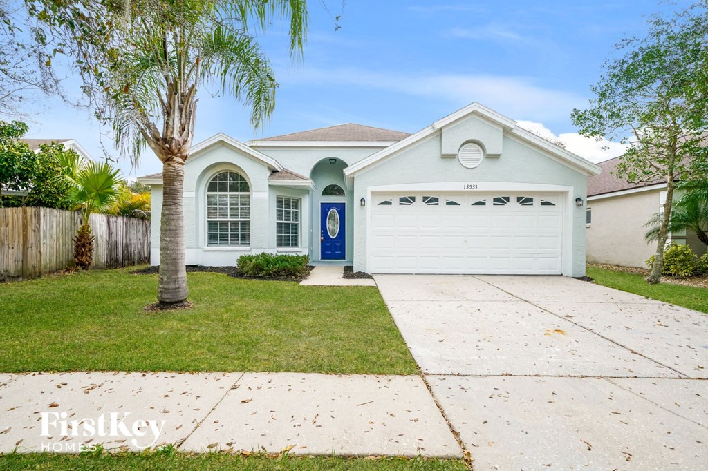 A white house with a blue door and garage door.