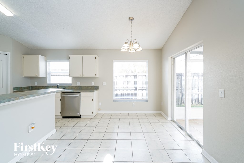 A kitchen with white cabinets and a white dishwasher.