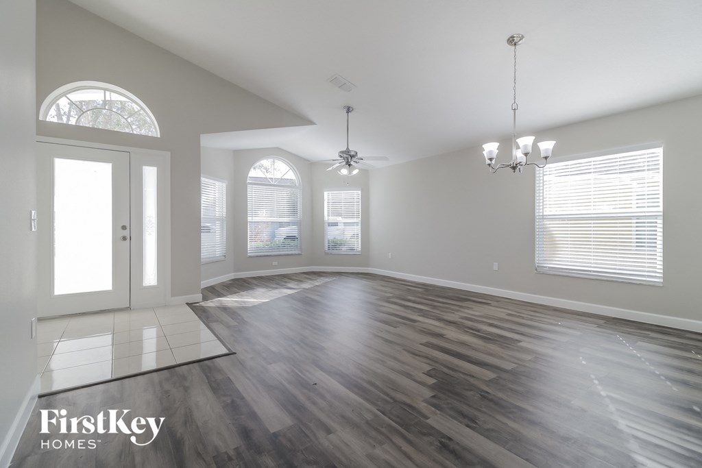 the living room of an empty house with wood floors and a window