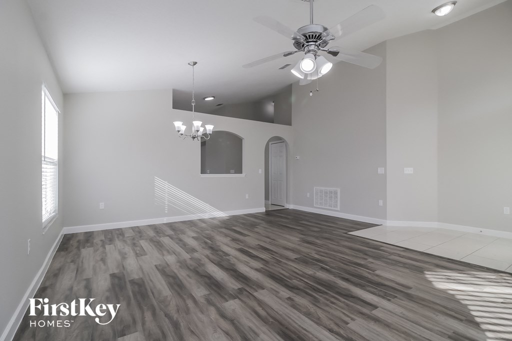 a living room with wood floors and a ceiling fan