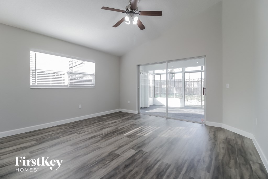 the living room of an empty house with a ceiling fan