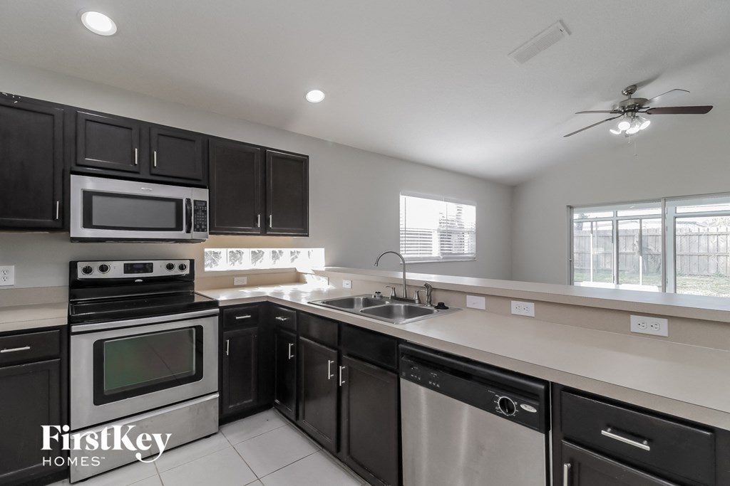 a kitchen with black cabinets and stainless steel appliances