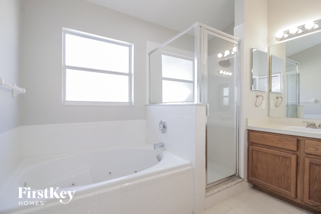 a white bathroom with a large tub and a shower