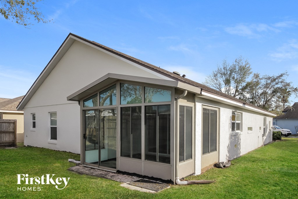 the exterior of a house with a patio and glass doors