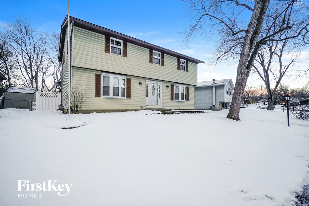 a yellow house with white snow on the ground